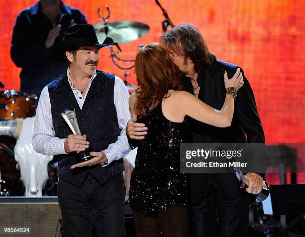 Musician Reba McEntire presents the ACM Milestone Award to musicians Kix Brooks and Ronnie Dunn of Brooks & Dunnn onstage during Brooks & Dunn's The...