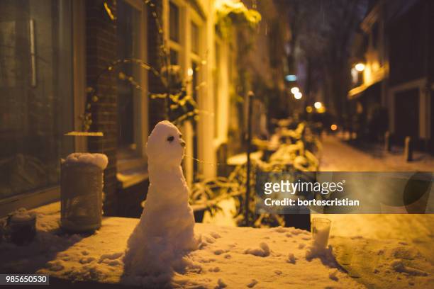 close-up of snowman at night - bortes stock-fotos und bilder