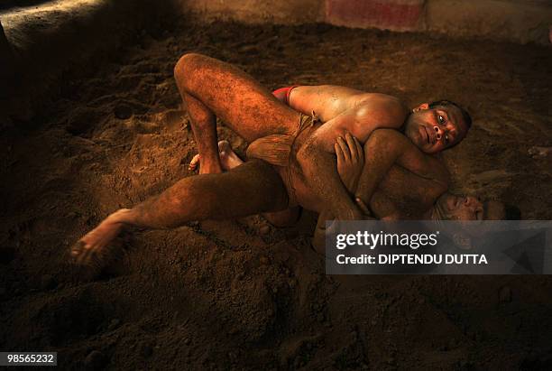 Indian wrestlers practice their mud wrestling skills at Loknath Akhara in Allahabad on April 19, 2010. India's indigenous form of wrestling and once...