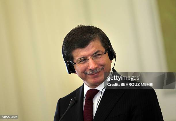 Turkish foreign minister Ahmet Davutoglu listens to his Iranian counterpart Manouchehr Mottaki during a joint press conference in Tehran on April 20,...