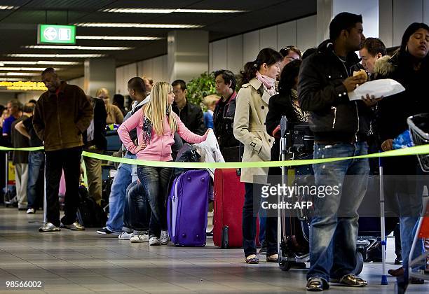 Passengers wait to complete check-in formalities at Schiphol Airport, near Amsterdam on April 20, 2010. Some flights resumed after Three flights...