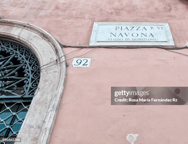 piazza navona street sign on old flaking paint wall and part of wrought iron metal doorway, roma, italy, europe. - rz stock pictures, royalty-free photos & images