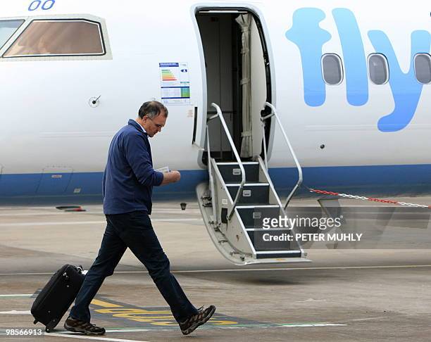 Passenger checks his ticket as he prepares to board the first Flybe flight given clearance to depart from Belfast City Airport in Belfast, Northern...