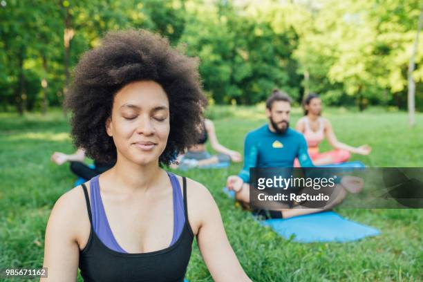 african american woman exercising yoga at the park - sitting eyes closed stock pictures, royalty-free photos & images