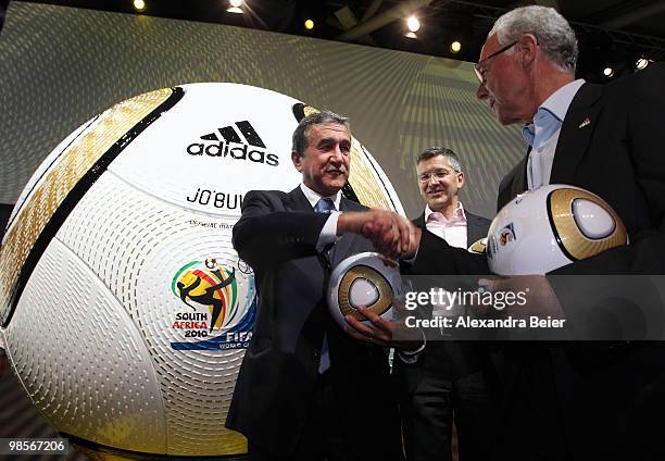 Head coach of the South African national football team Carlos Alberto Parreira shakes hands with German football legend Franz Beckenbauer as Adidas...