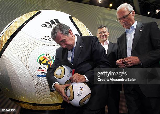 Head coach of the South African national football team Carlos Alberto Parreira signs the new World Cup final matchball next to Adidas CEO Herbert...