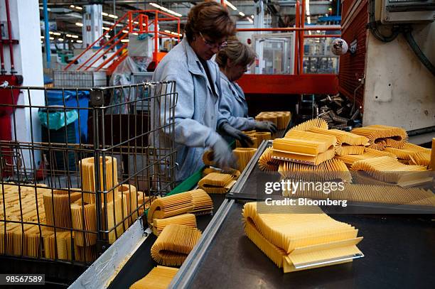 Oil filters made for Alfa Romeo Mito automobiles pass down a conveyor belt at the Tecnocar car parts factory, operated by Sogefi SpA, near Turin,...