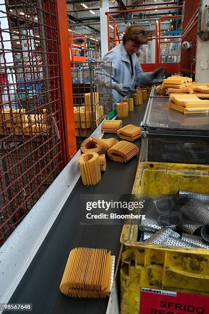 Oil filters made for Alfa Romeo Mito automobiles pass down a conveyor belt at the Tecnocar car parts factory, operated by Sogefi SpA, near Turin,...