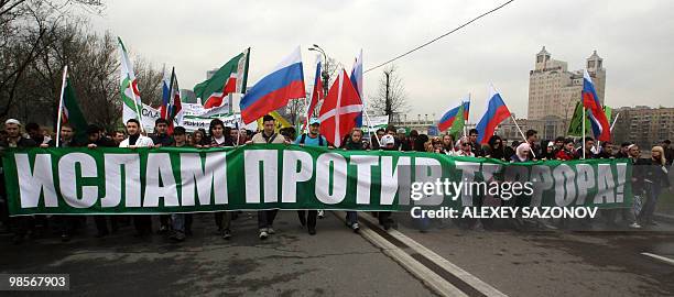 Moscow muslims march along a street in Moscow on April 20, 2010 with a poster bearing a slogan which translates as "Islam Against Terrorism!" in...