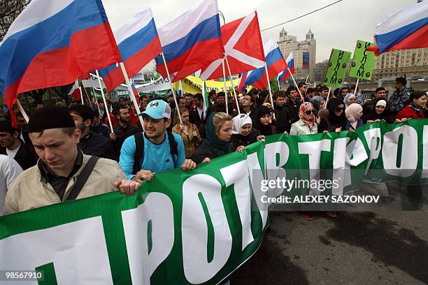 Moscow muslims march along a street in Moscow on April 20, 2010 with a poster bearing a slogan which translates as "Islam Against Terrorism!" in...