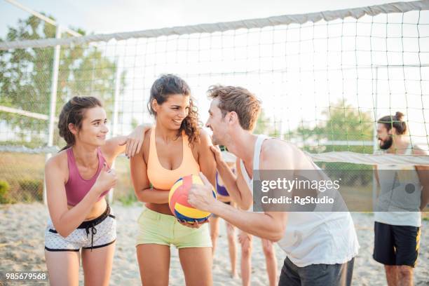 amigos jugando voleibol - campeón de torneo fotografías e imágenes de stock