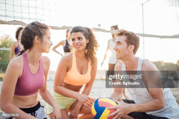 amigos hablando y descansando mientras jugaba voleibol - campeón de torneo fotografías e imágenes de stock