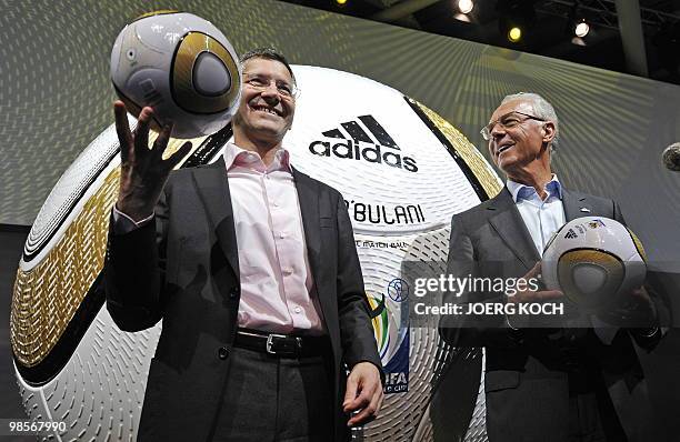Herbert Hainer , CEO of German sports equipment and clothing maker Adidas and German football legend Franz Beckenbauer pose for photographers with...