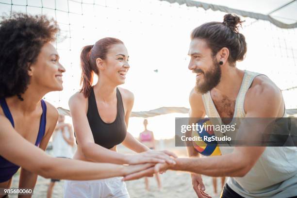 amigos de apilar las palmas en una pila y sonriendo mientras lo hace - campeón de torneo fotografías e imágenes de stock