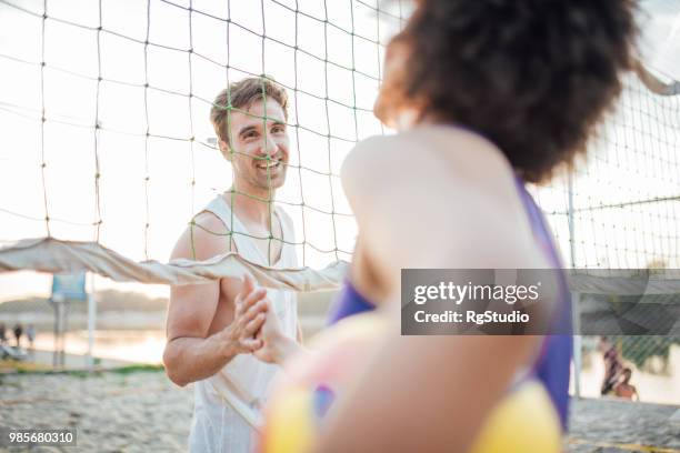 hombre feliz agitando las manos con una mujer de la selección de voleibol de enfrente - campeón de torneo fotografías e imágenes de stock