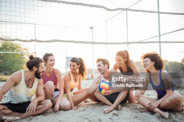 jugadores de voleibol feliz en la playa - campeón de torneo fotografías e imágenes de stock