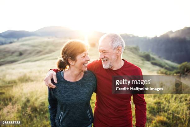 senior active couple standing outdoors in nature in the foggy morning. - active lifestyle stock-fotos und bilder