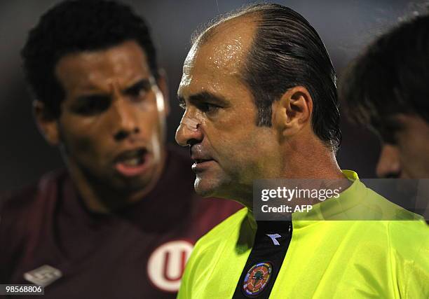 Uruguayan referee Dario Ubriaco talks with forward Piero Alva of Peru's Universitario during a Libertadores Cup Group 4 football match against...