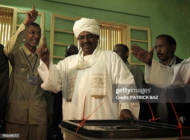 Members of Sudanese President Omar al-Beshir's entourage shout "God is Great" after casting his vote at the St Francis Christian school turned into a...