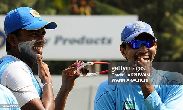 Sri Lankan cricketer Chinthaka Jayasinghe laughs with Suraj Randiv during a practice session at the P.Sara Stadium in Colombo on April 20, 2010. Sri...