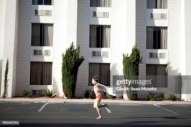 boy running through parking lot with towel cape - las vegas crazy stock pictures, royalty-free photos & images