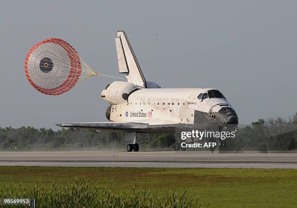The US space shuttle Discovery deploys its drag chute April 20, 2010 at Kennedy Space Center's runway 33 in Florida completing fifteen days in space....