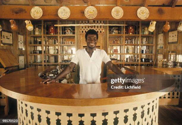 Basil Charles behind the bar at Basil's on Mustique, in the West Indies, 9th March 1972. .