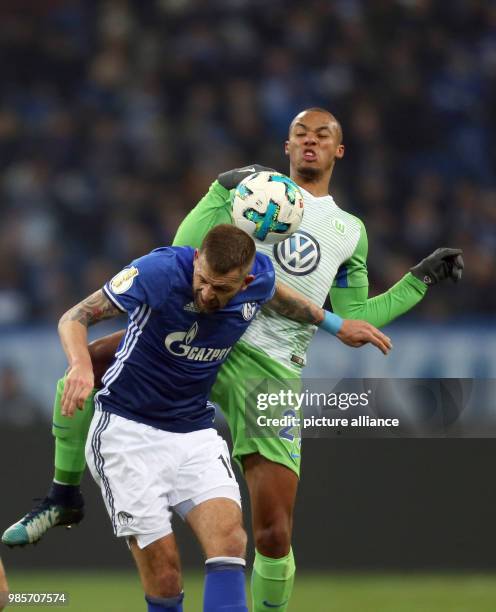 Schalke's Guido Burgstaller and Wolfsburg's Marcel Tisserand vie for the ball during the German DFB Cup quarterfinal match between FC Schalke 04 and...