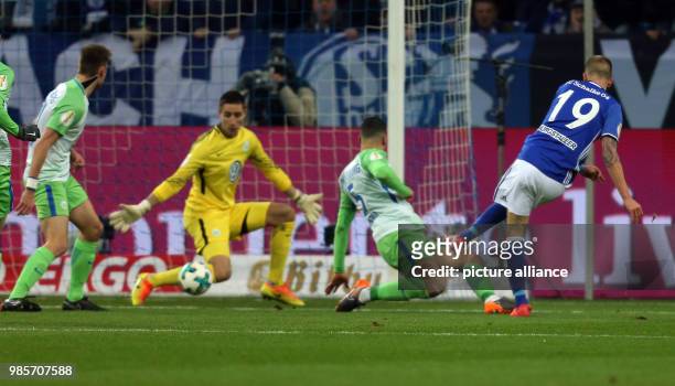 Dpatop - Schalke's Guido Burgstaller scores his side's 1st goal against Wolfsburg's Koen Casteels during the German DFB Cup quarterfinal match...