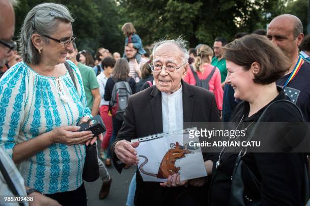 Romanian philosopher Mihai Sora holds a placard depicting a rat that looks through a binocular, during a protest in front of the prime minister's...