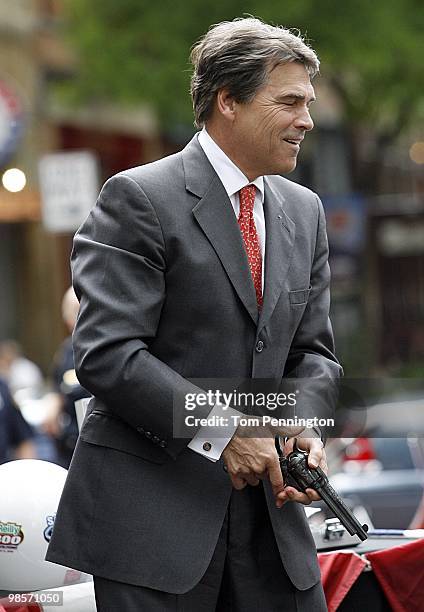 Texas Governor Rick Perry carries a six-shooter revolver in downtown Fort Worth during a promotional event with Texas Motor Speedway on April 15,...