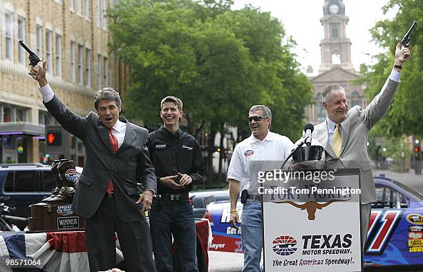 Texas Governor Rick Perry, left, and Fort Worth mayor Mike Moncrief, right, fire six-shooter pistols with NASCAR drivers Colin Braun and Bobby...