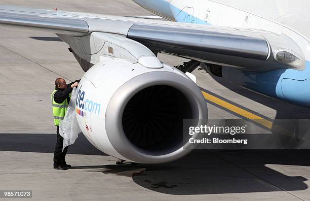 Airline ground crew prepare to cover the engine of a Flybe aircraft as it sits on the tarmac at Birmingham International airport in Birmingham, U.K.,...