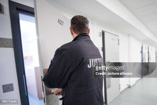 Prison guard locking a cell's door in the recently renovated B-wing of the Holstenglacis remand centre during a tour for the press in Hamburg,...