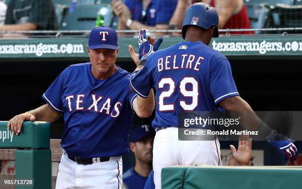 Adrian Beltre of the Texas Rangers celebrates a run with Jeff Banister in the third inning against the San Diego Padres at Globe Life Park in...