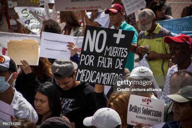 People protest because of the lack of medicine in Caracas, Venezuela, 8 February 2018. On a banner is written 'No more deaths because of lack of...