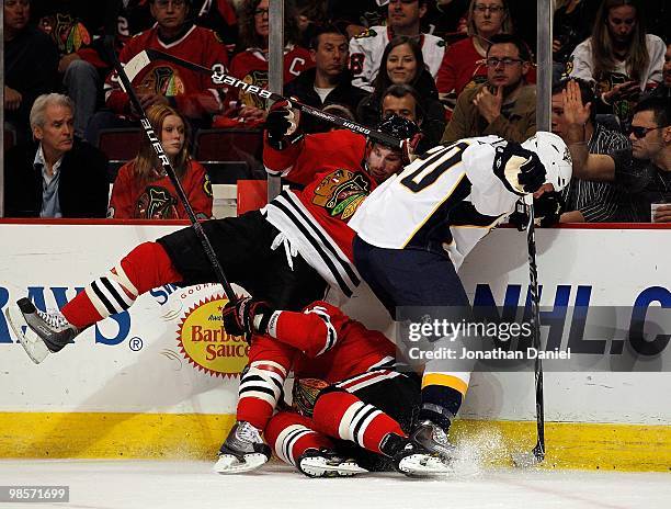 Troy Brouwer of the Chicago Blackhawks falls over teammate Kris Versteeg as they battle for the puck with Ryan Suter of the Nashville Predators in...