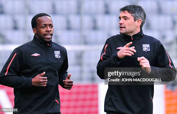 Lyon striker Sydney Govou and defender Jeremy Toulalan warm up during a training session at the Allianz Arena in the southern German city of Munich...