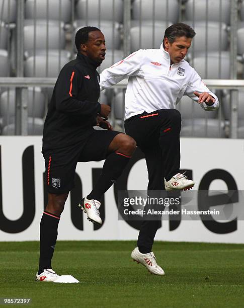 Sidney Govou of Olympic Lyon runs with Claude Puel , head coach of Lyon during a training session at Allianz Arena on April 20, 2010 in Munich,...