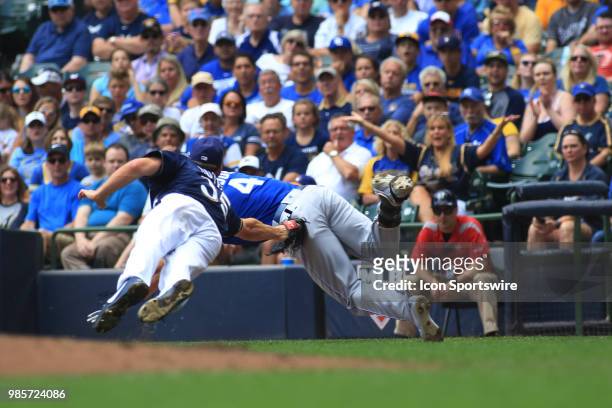 Milwaukee Brewers starting pitcher Brent Suter dives and tags Kansas City Royals left fielder Alex Gordon during a game between the Milwaukee Brewers...