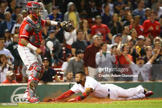 Eduardo Nunez of the Boston Red Sox slides safely into home plate past Martin Maldonado of the Los Angeles Angels in the seventh inning a game at...