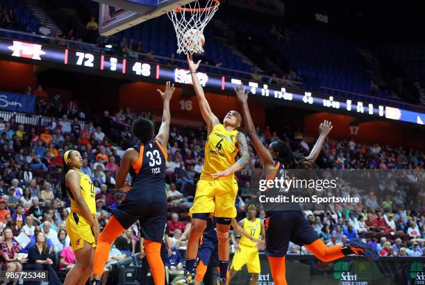 Indiana Fever forward Candice Dupree drives to the basket against Connecticut Sun forward Morgan Tuck and Connecticut Sun forward Jonquel Jones...