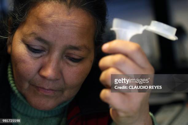 Chilean Josefina Sandoval holds a test tube containing saliva during an interview with AFP in Santiago, on June 10, 2018. - Josefina Sandoval gave...