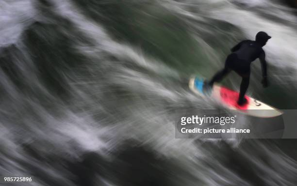 Man surfs at the Eisbach of the wintry Englischer Garten in Munich, 9 February 2018. Photo: Karl-Josef Hildenbrand/dpa
