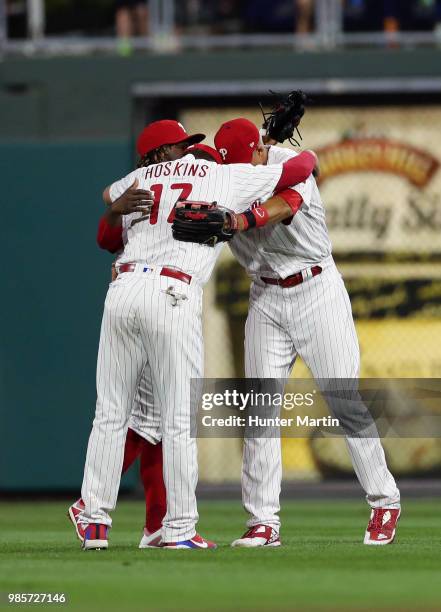 Outfielders Rhys Hoskins, Odubel Herrera and Aaron Altherr of the Philadelphia Phillies have a group hug in celebration of a win over the New York...