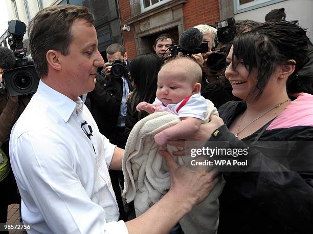 British opposition Conservative party leader, David Cameron, holds a baby while campaigning in Tamworth, central England on April 20, 2010. The...