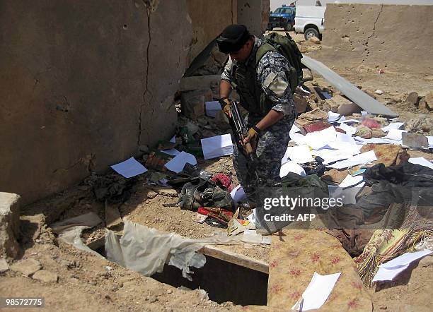 An Iraqi soldier searches the site where allegedly top Al-Qaeda leaders in Iraq, Abu Omar al-Baghdadi and Abu Ayyub al-Masri, were killed in a joint...