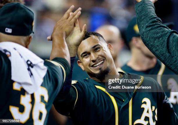 Franklin Barreto of the Oakland Athletics is congratulated by Yusmeiro Petit of the Oakland Athletics after scoring on a double by Josh Phegley...