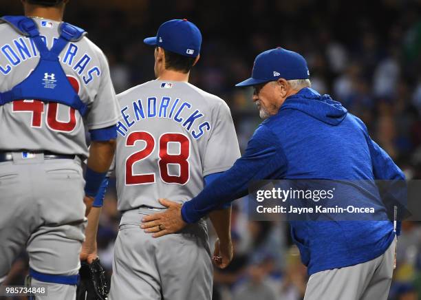 Willson Contreras looks on as manager Joe Maddon pulls starting pitcher Kyle Hendricks of the Chicago Cubs in the third inning of the game against...