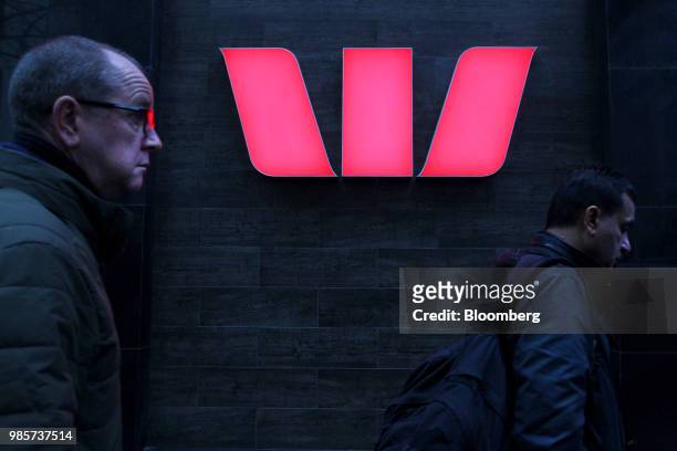 Pedestrians walk past signage for the Westpac Banking Corp. Outside the company's branch in the central business district of Sydney, Australia, on...